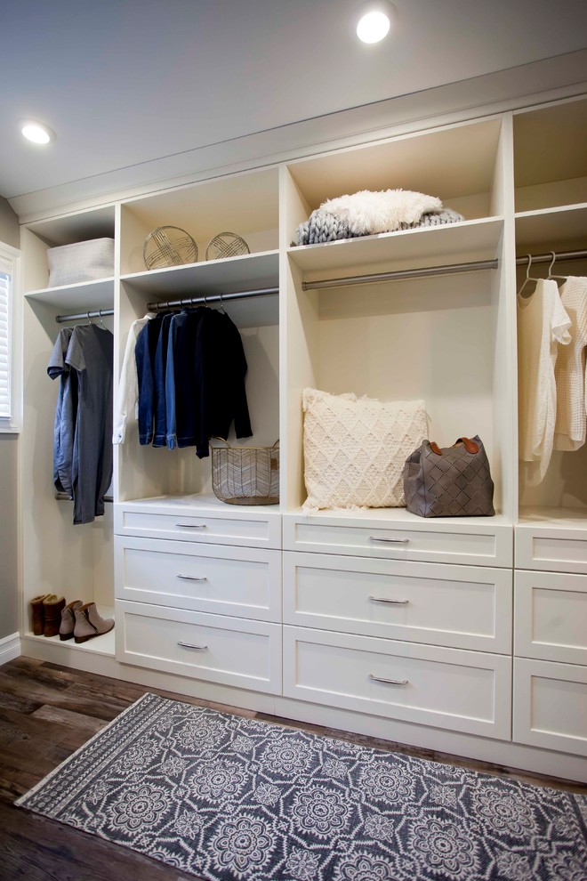 Photo of a large contemporary gender-neutral walk-in wardrobe in Calgary with open cabinets, white cabinets, medium hardwood floors and brown floor.