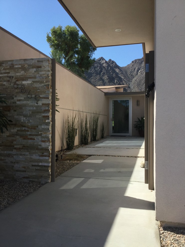 Design ideas for a mid-sized midcentury front door in Orange County with beige walls, concrete floors, a single front door and a glass front door.