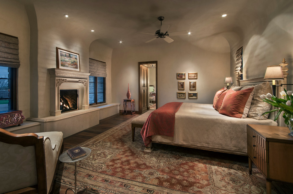 Photo of a large traditional master bedroom in Phoenix with white walls, medium hardwood floors, a standard fireplace and a stone fireplace surround.