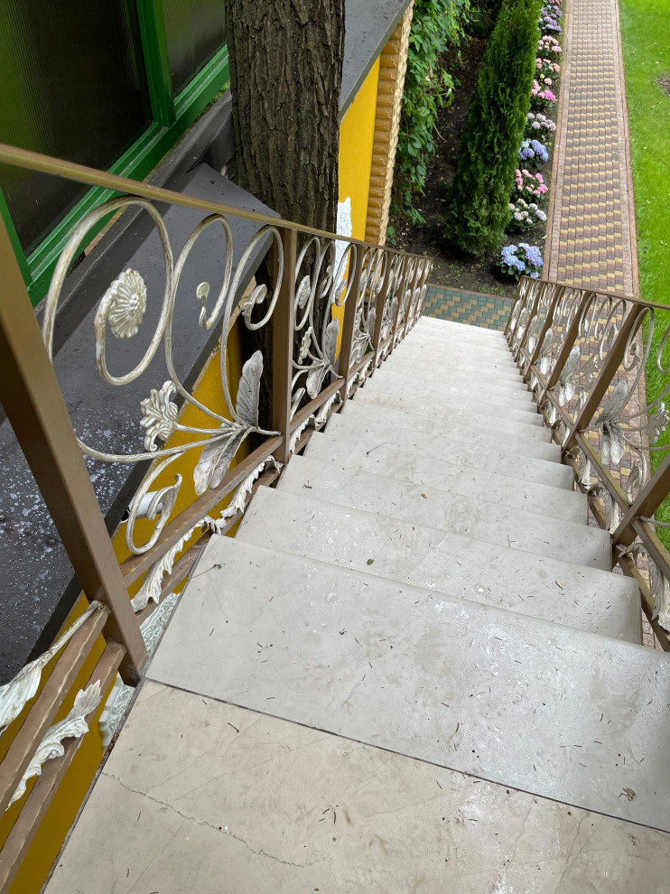 Exempel på en mellanstor asiatisk rak trappa, med klinker och räcke i metall