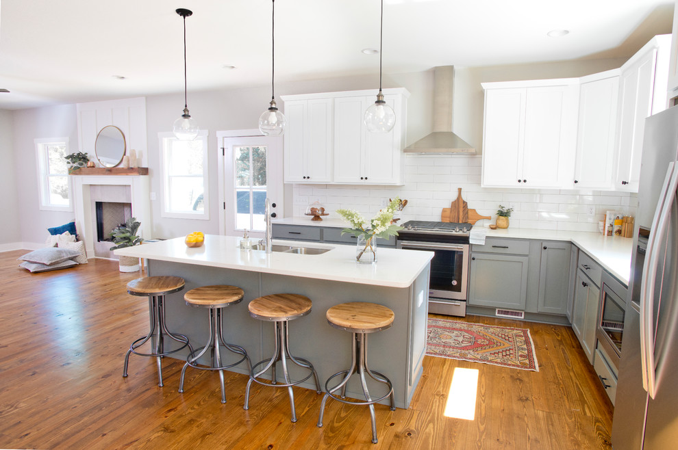 Transitional l-shaped kitchen photo with stainless steel appliances and an island
