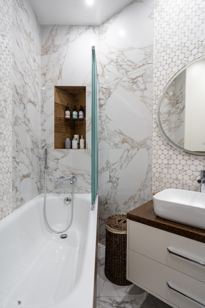 This is an example of a contemporary master bathroom in Moscow with flat-panel cabinets, grey cabinets, an alcove tub, a shower/bathtub combo, white tile, brown benchtops, a single vanity and a floating vanity.