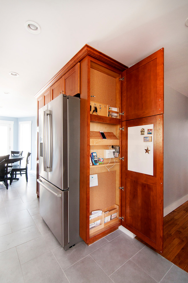 Small arts and crafts gender-neutral built-in wardrobe in Boston with shaker cabinets, medium wood cabinets, ceramic floors and grey floor.