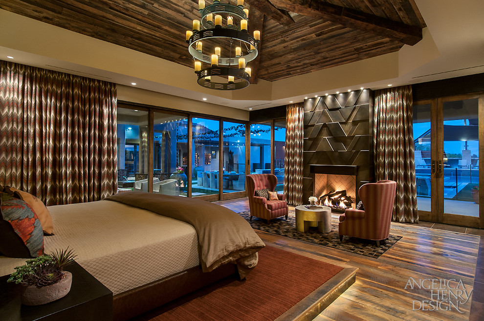 Bedroom - rustic master medium tone wood floor bedroom idea in Phoenix with beige walls, a standard fireplace and a metal fireplace