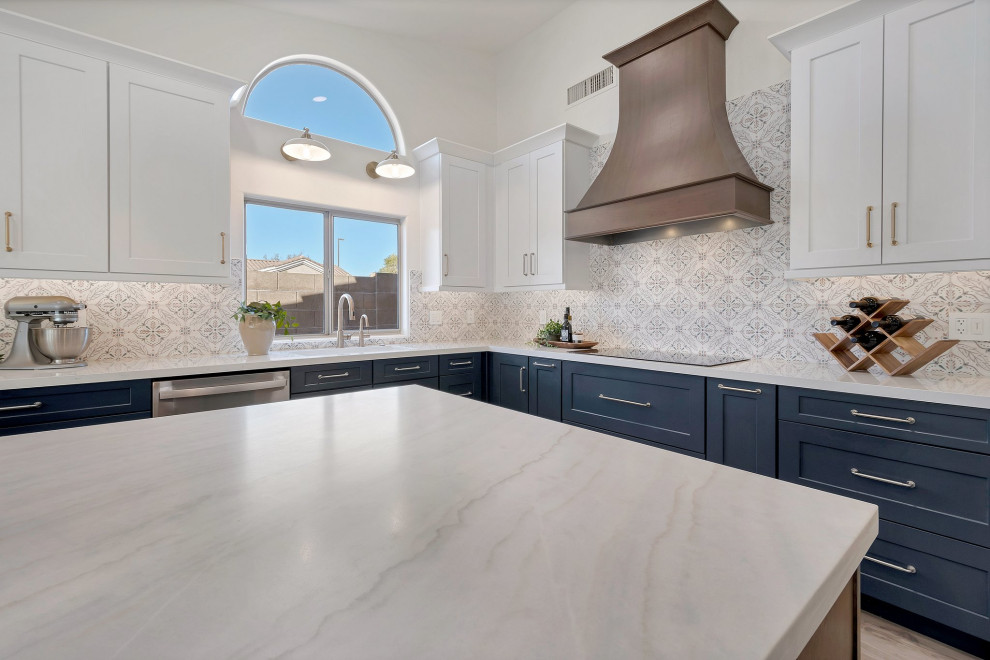 Inspiration for a large transitional l-shaped porcelain tile, brown floor and vaulted ceiling eat-in kitchen remodel in Phoenix with an undermount sink, shaker cabinets, blue cabinets, quartzite countertops, multicolored backsplash, mosaic tile backsplash, stainless steel appliances, two islands and white countertops