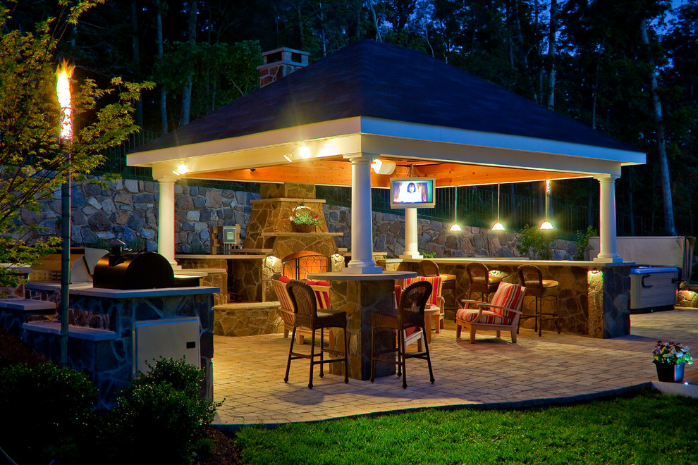 Photo of a mid-sized traditional backyard patio in DC Metro with a fire feature, concrete pavers and a gazebo/cabana.