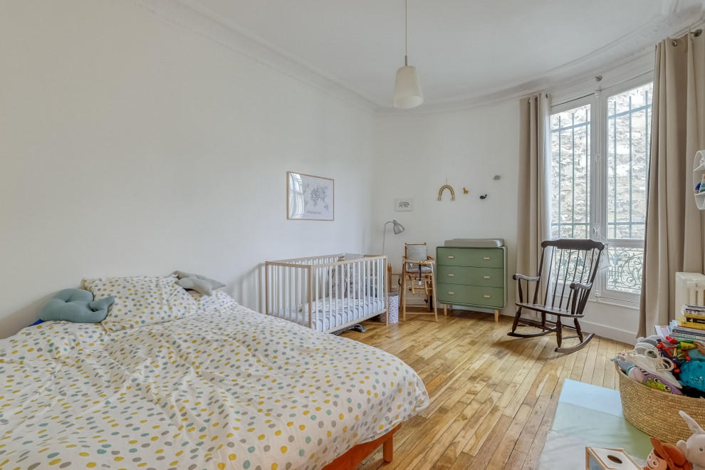 Imagen de dormitorio infantil de 4 a 10 años contemporáneo grande con paredes blancas, suelo de madera clara y suelo marrón