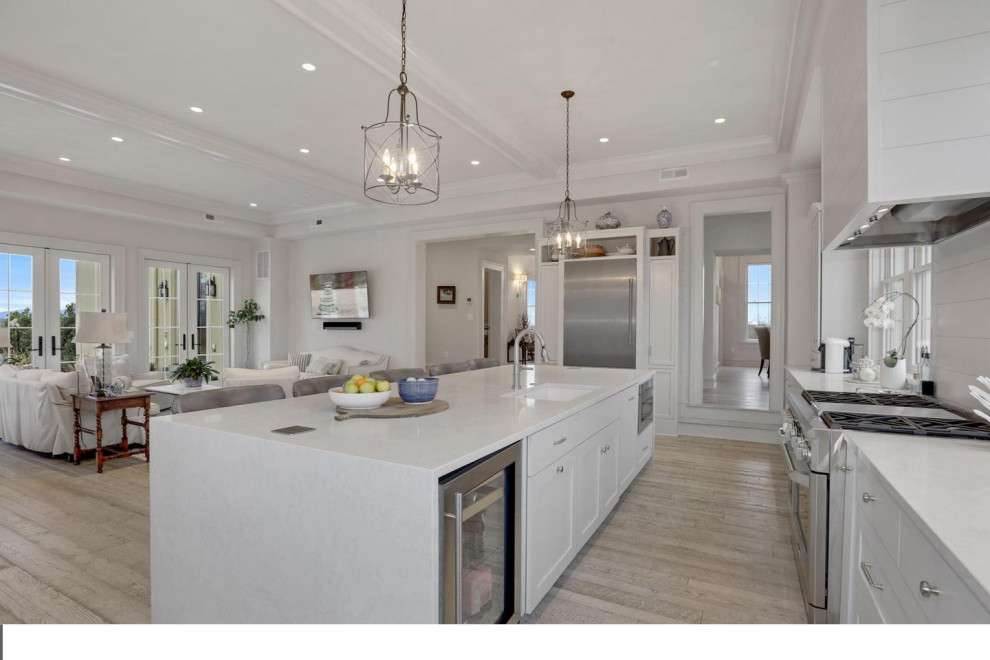 Large transitional single-wall light wood floor eat-in kitchen photo in DC Metro with an undermount sink, shaker cabinets, white cabinets, quartz countertops, stainless steel appliances and an island