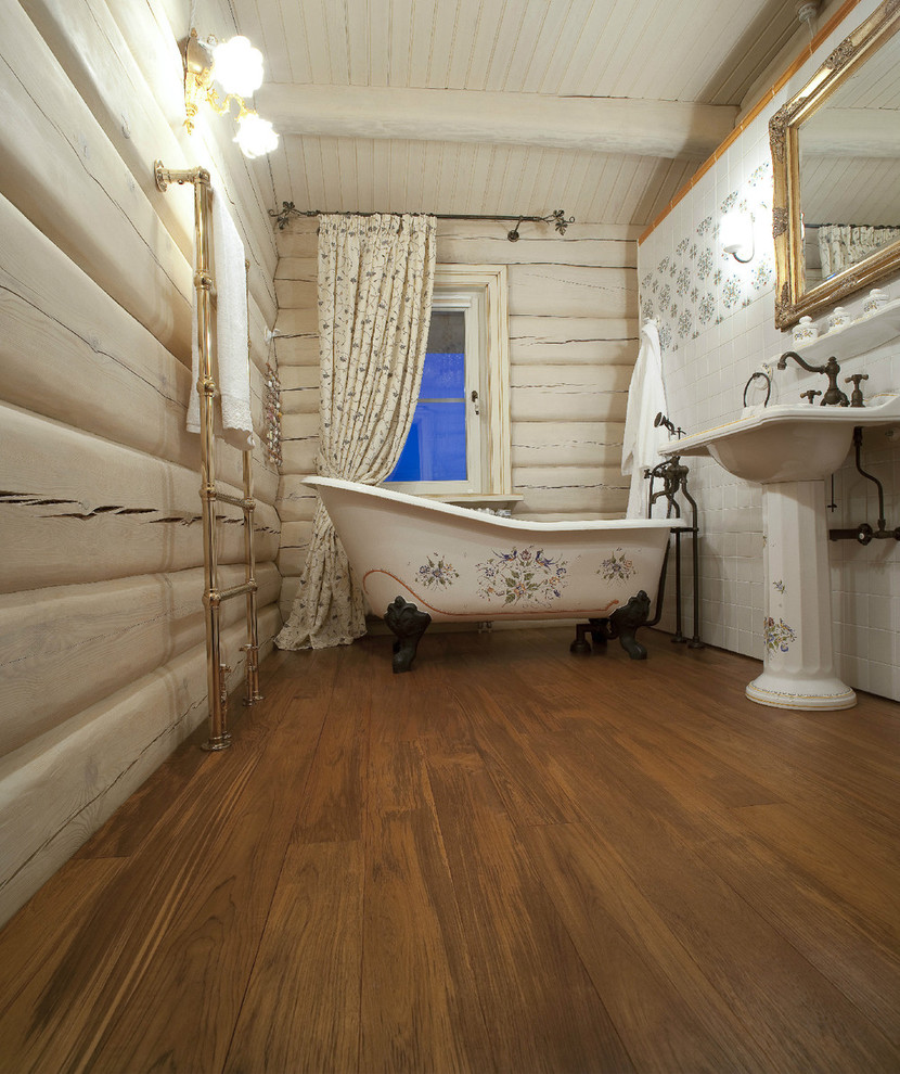 Inredning av ett mellanstort en-suite badrum, med ett badkar med tassar, vit kakel, keramikplattor, vita väggar, mörkt trägolv och ett integrerad handfat