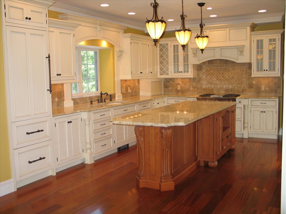 This is an example of a traditional u-shaped eat-in kitchen in Boston with an undermount sink, beaded inset cabinets, white cabinets, beige splashback and stainless steel appliances.