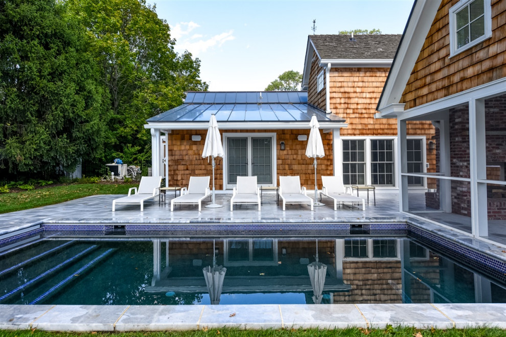 Esempio di una piscina chic rettangolare di medie dimensioni e dietro casa con pavimentazioni in pietra naturale