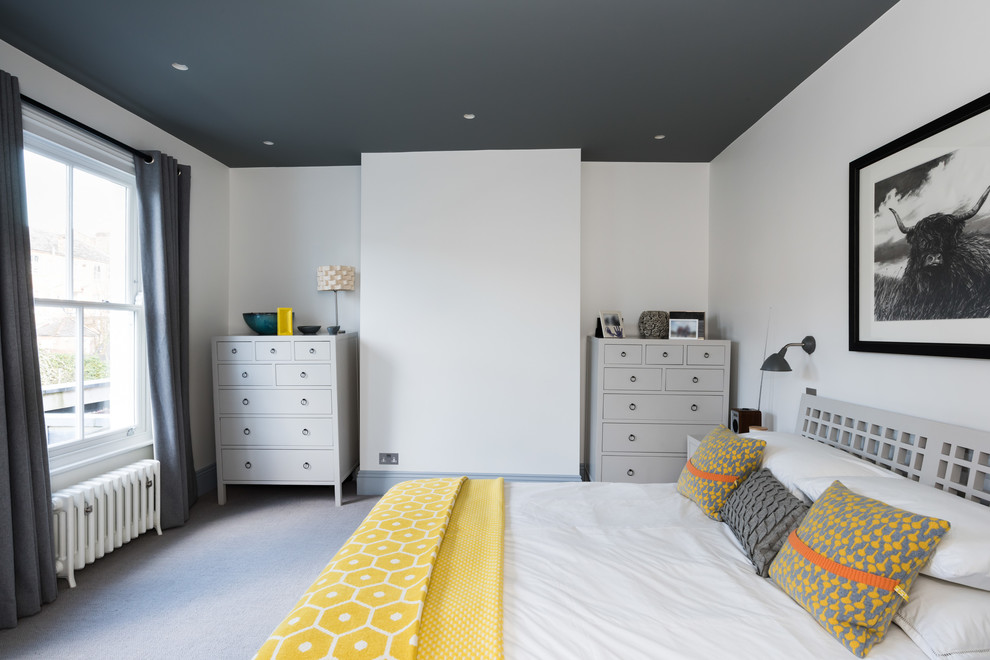 This is an example of a large contemporary guest bedroom in London with beige walls, carpet, no fireplace and grey floor.
