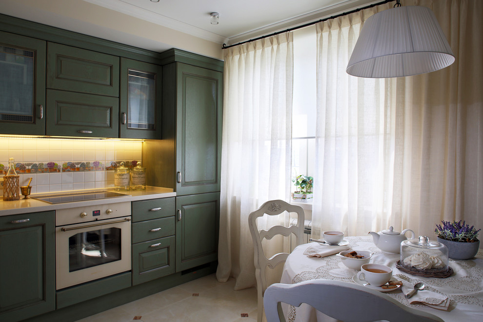 Small traditional l-shaped separate kitchen in Moscow with beige floor, an undermount sink, recessed-panel cabinets, green cabinets, solid surface benchtops, white splashback, ceramic splashback, white appliances, porcelain floors and white benchtop.