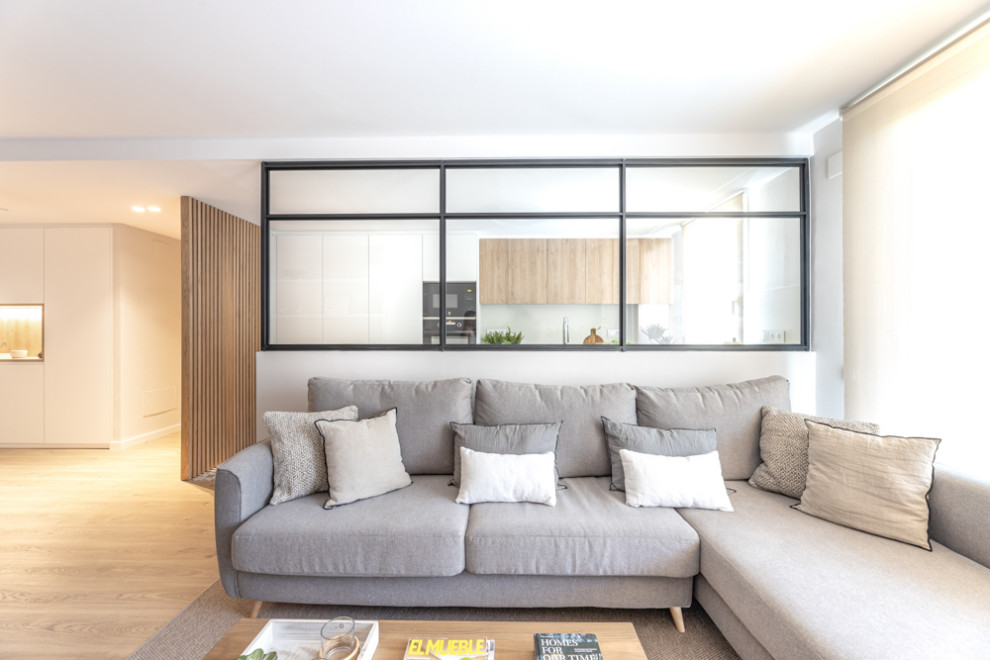 Medium sized scandi open plan dining room in Barcelona with white walls, medium hardwood flooring and brown floors.