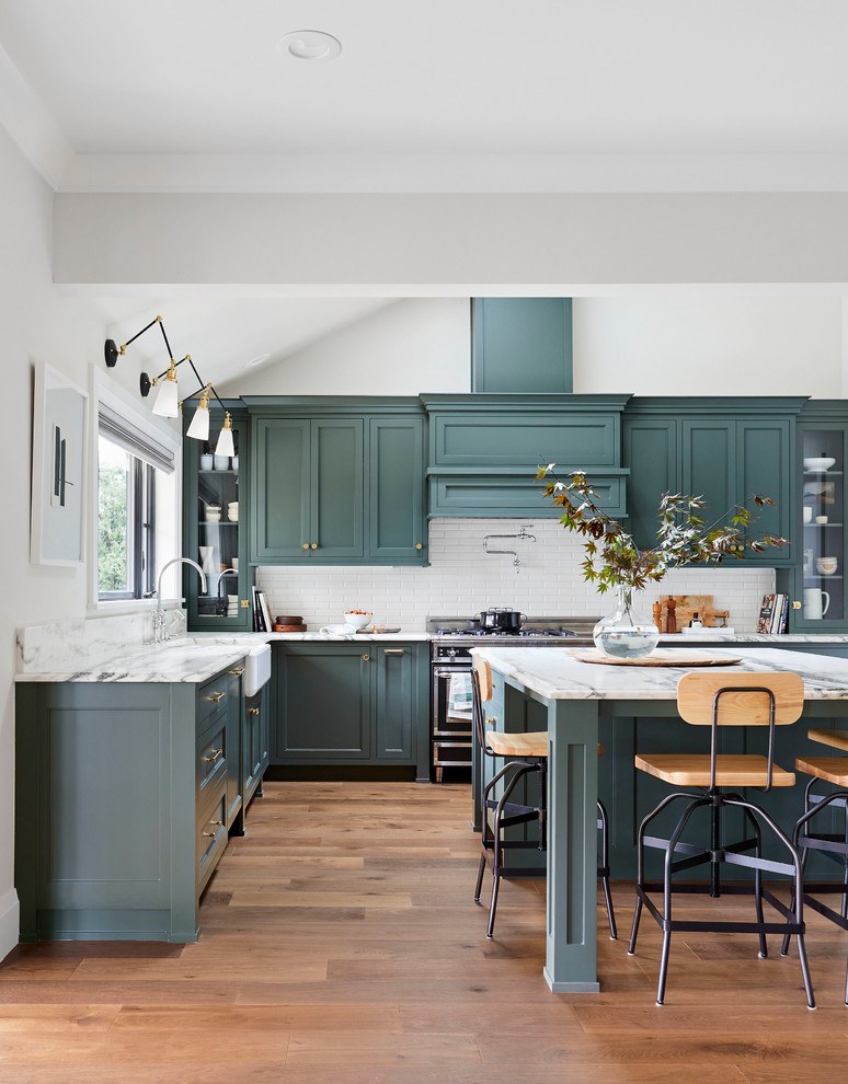 Kitchen - transitional l-shaped medium tone wood floor and brown floor kitchen idea with a farmhouse sink, shaker cabinets, blue cabinets, white backsplash, an island and gray countertops