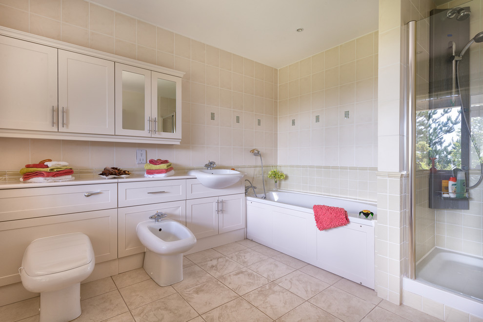 Inspiration for a large traditional bathroom in Devon with a drop-in sink, recessed-panel cabinets, white cabinets, laminate benchtops, an alcove tub, a double shower, a one-piece toilet, multi-coloured tile, ceramic tile, white walls and ceramic floors.