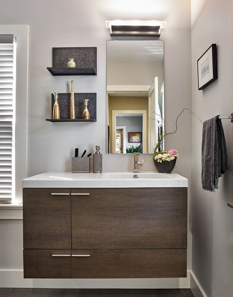 This is an example of a mid-sized contemporary bathroom in Other with flat-panel cabinets, dark wood cabinets, grey walls, dark hardwood floors and an integrated sink.