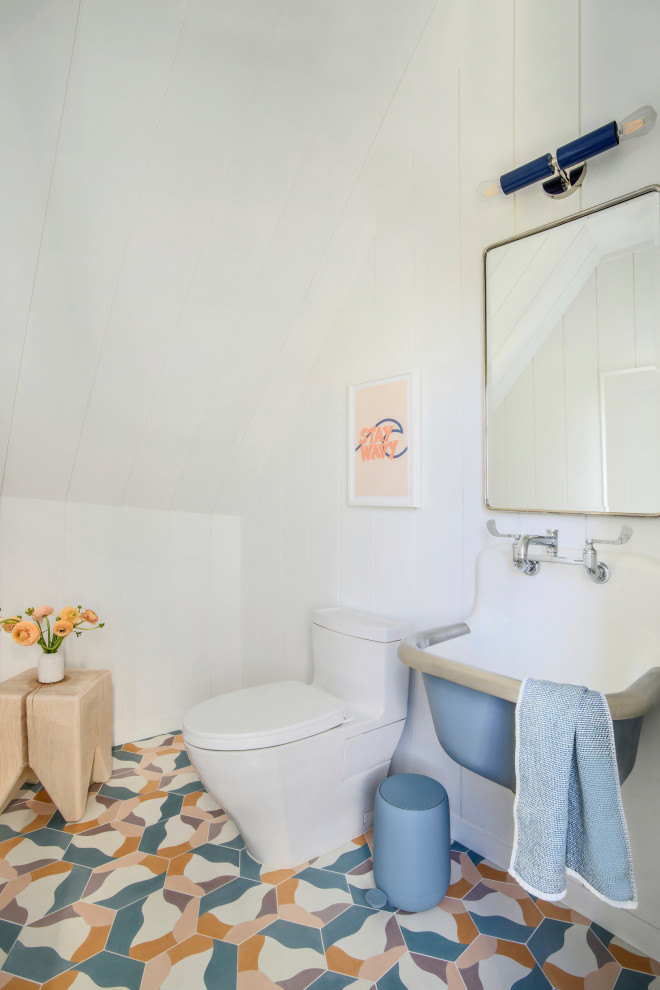 Beach style cloakroom in New York with white walls, a wall-mounted sink, multi-coloured floors, a timber clad ceiling, a vaulted ceiling, tongue and groove walls and a one-piece toilet.