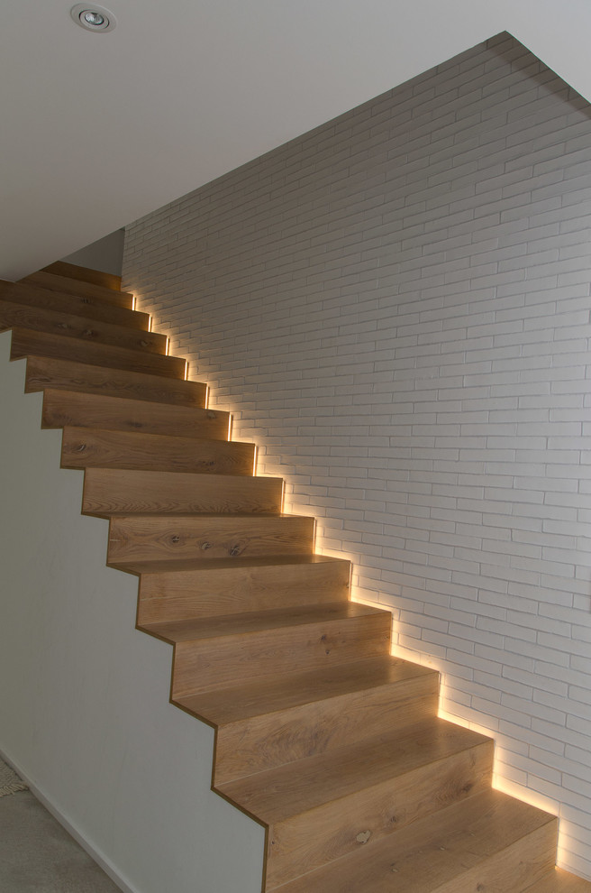 Design ideas for a mid-sized modern wood straight staircase in Frankfurt with wood risers.