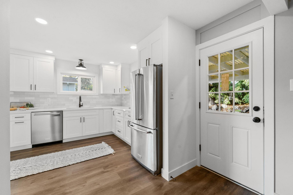 Example of a transitional galley dark wood floor and brown floor eat-in kitchen design in Seattle with an undermount sink, shaker cabinets, white cabinets, quartzite countertops, gray backsplash, ceramic backsplash, stainless steel appliances, no island and white countertops