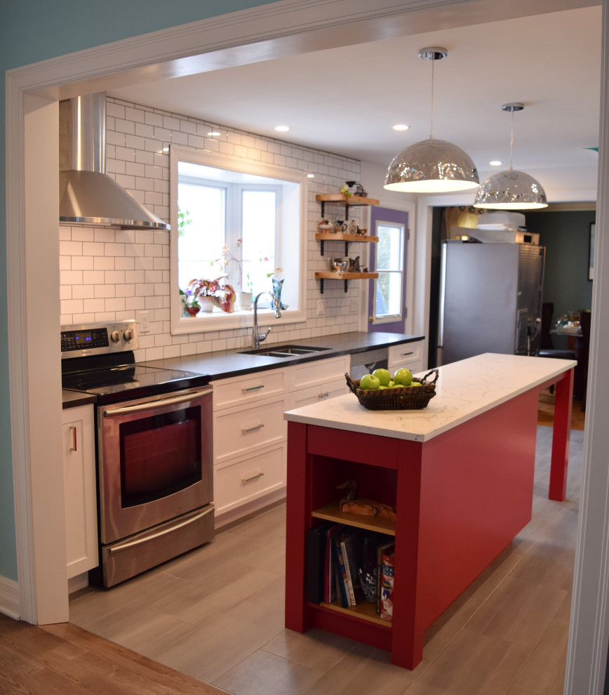 Enclosed kitchen - small eclectic galley light wood floor and beige floor enclosed kitchen idea in Ottawa with an undermount sink, shaker cabinets, white cabinets, quartz countertops, white backsplash, subway tile backsplash, stainless steel appliances, an island and white countertops