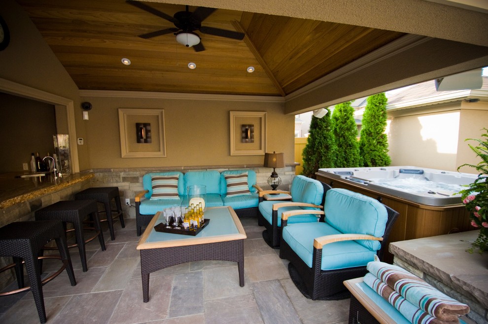 Transitional backyard stone patio photo in Toronto with a gazebo