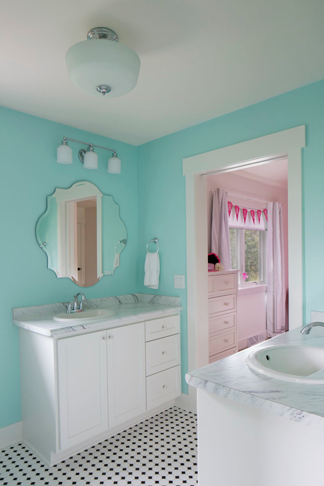 Design ideas for a mid-sized traditional kids bathroom in Milwaukee with shaker cabinets, white cabinets, a corner shower, a one-piece toilet, blue walls, granite benchtops, porcelain floors and a drop-in sink.