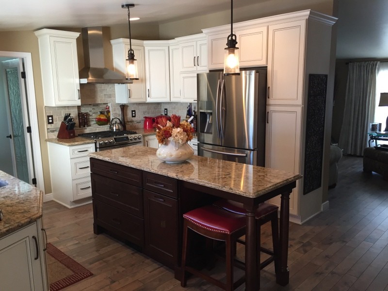 Mid-sized transitional u-shaped medium tone wood floor eat-in kitchen photo with an undermount sink, flat-panel cabinets, dark wood cabinets, quartz countertops, beige backsplash, stone tile backsplash, stainless steel appliances and an island