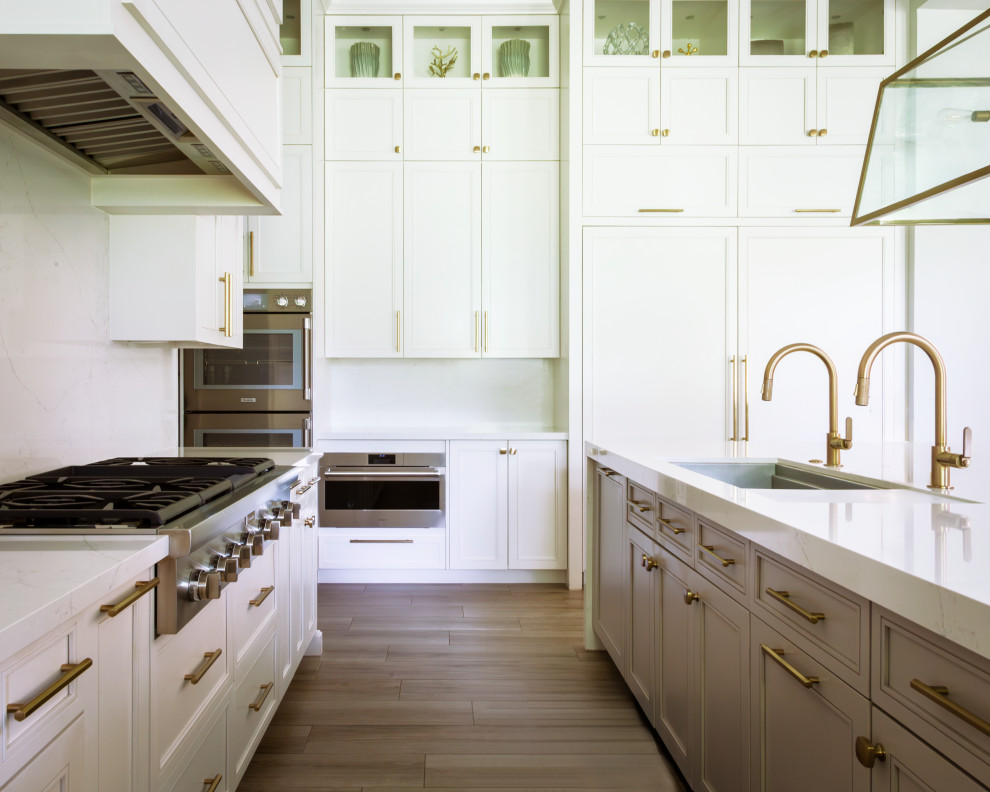 Inspiration for a transitional u-shaped beige floor and porcelain tile open concept kitchen remodel with a drop-in sink, white backsplash, stainless steel appliances, an island, white countertops, white cabinets, quartz countertops and stone tile backsplash