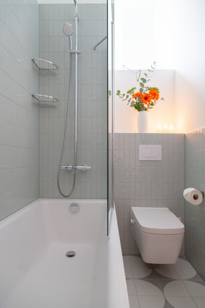 Foto på ett mellanstort funkis vit badrum med dusch, med luckor med upphöjd panel, grå skåp, ett platsbyggt badkar, en dusch/badkar-kombination, en toalettstol med separat cisternkåpa, grön kakel, keramikplattor, vita väggar, klinkergolv i keramik, ett integrerad handfat, laminatbänkskiva, grått golv och med dusch som är öppen