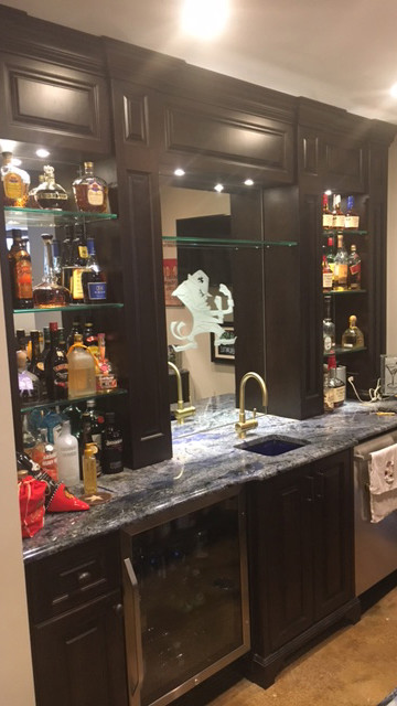 Photo of a mid-sized traditional single-wall bar cart in Chicago with an undermount sink, beaded inset cabinets, dark wood cabinets, granite benchtops, mirror splashback, concrete floors and beige floor.