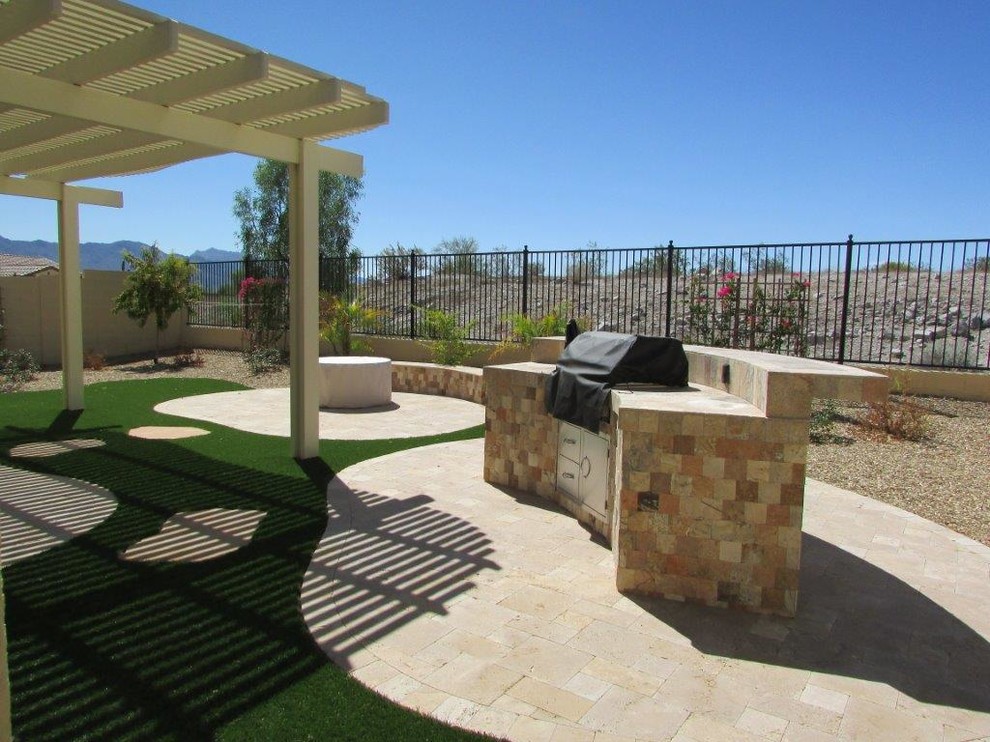 Inspiration for a mid-sized contemporary backyard patio in Phoenix with an outdoor kitchen, natural stone pavers and a pergola.