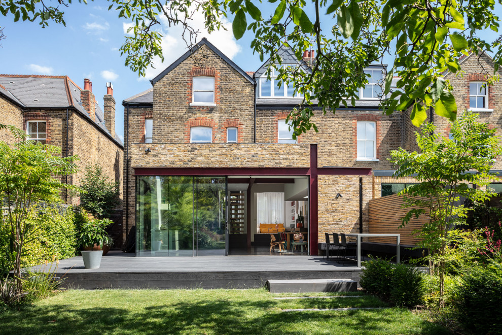 Inspiration for an expansive contemporary three-storey brick brown duplex exterior in London with a flat roof, a mixed roof and a grey roof.