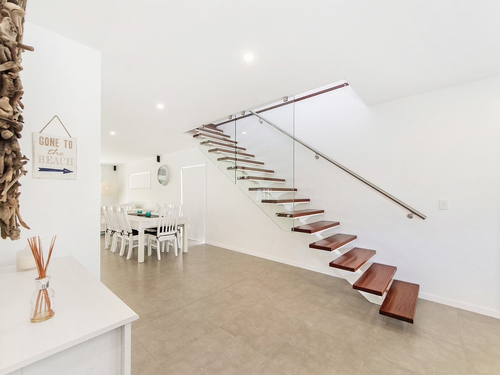 Photo of a beach style wood floating staircase in Gold Coast - Tweed with open risers.