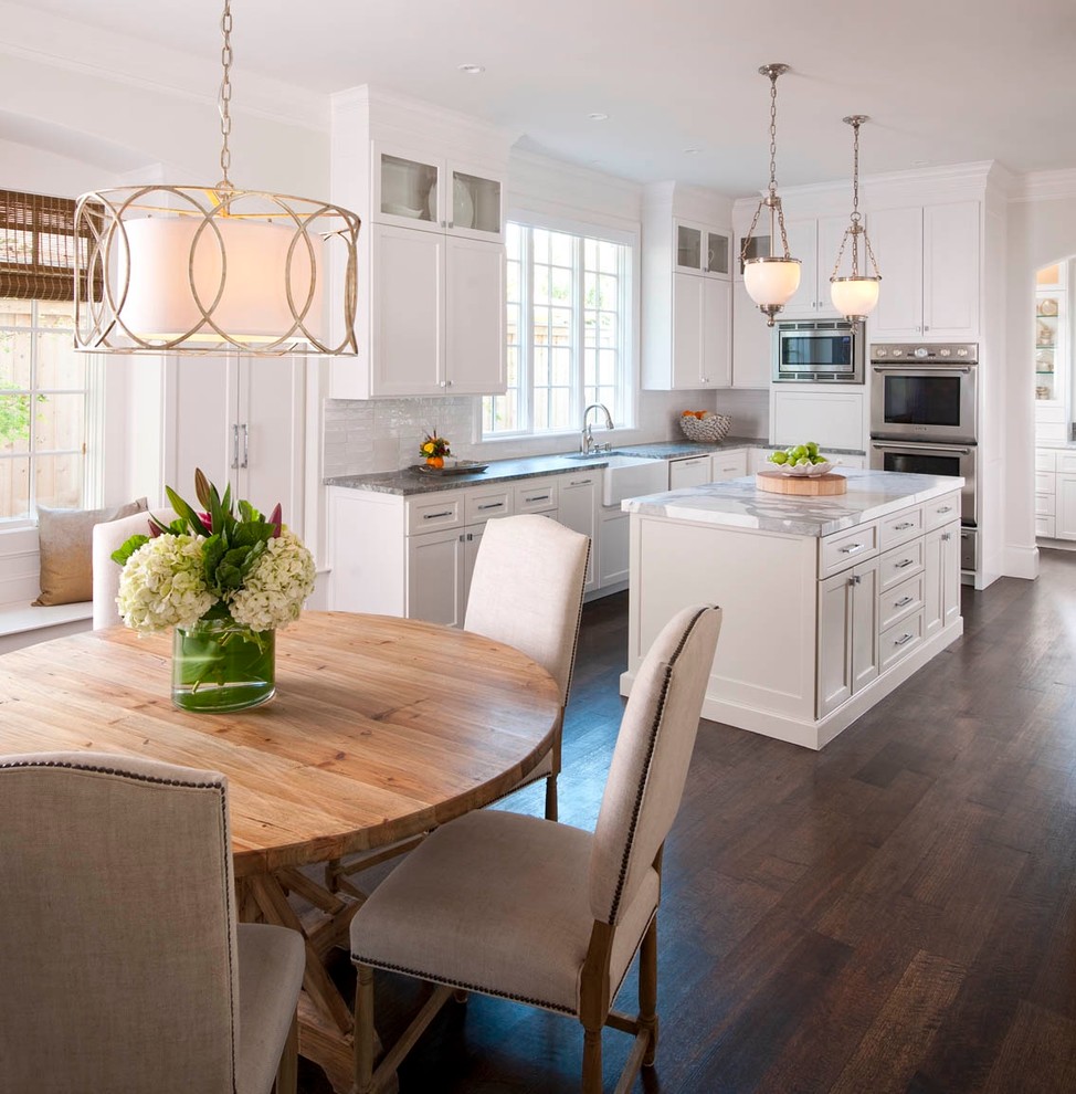 Inspiration for a traditional eat-in kitchen in Dallas with a farmhouse sink, recessed-panel cabinets, white cabinets, white splashback, marble benchtops and grey benchtop.