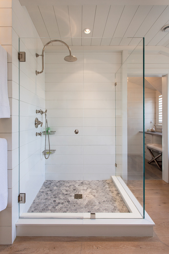 Photo of a large beach style master bathroom in Boston with a freestanding tub, a corner shower, white tile, ceramic tile, white walls and light hardwood floors.