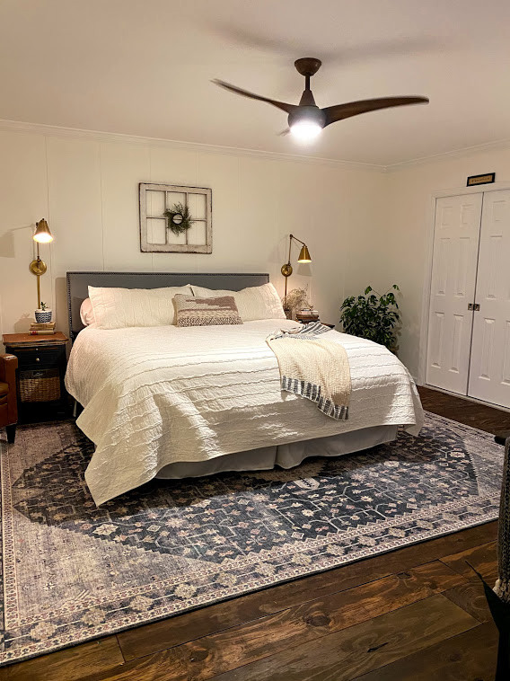This is an example of a medium sized country master bedroom in Philadelphia with white walls, dark hardwood flooring, no fireplace, brown floors and wainscoting.