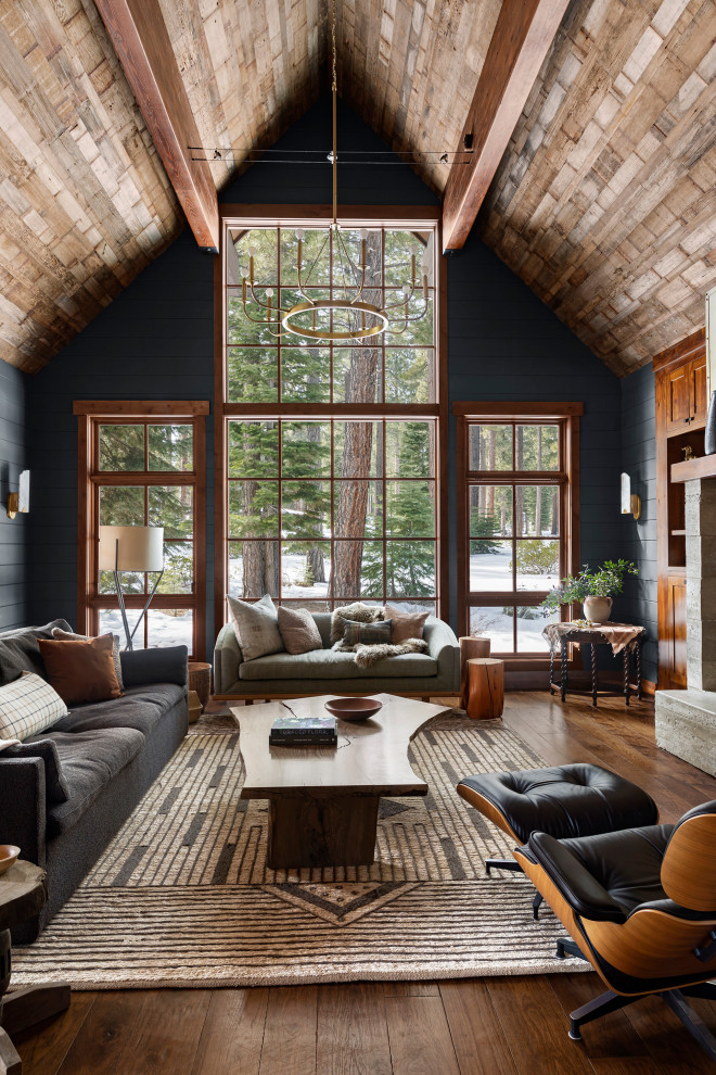 Aménagement d'un grand salon éclectique ouvert avec un mur noir, un sol en bois brun, une cheminée standard, un manteau de cheminée en métal, un sol marron, un plafond en bois et du lambris de bois.