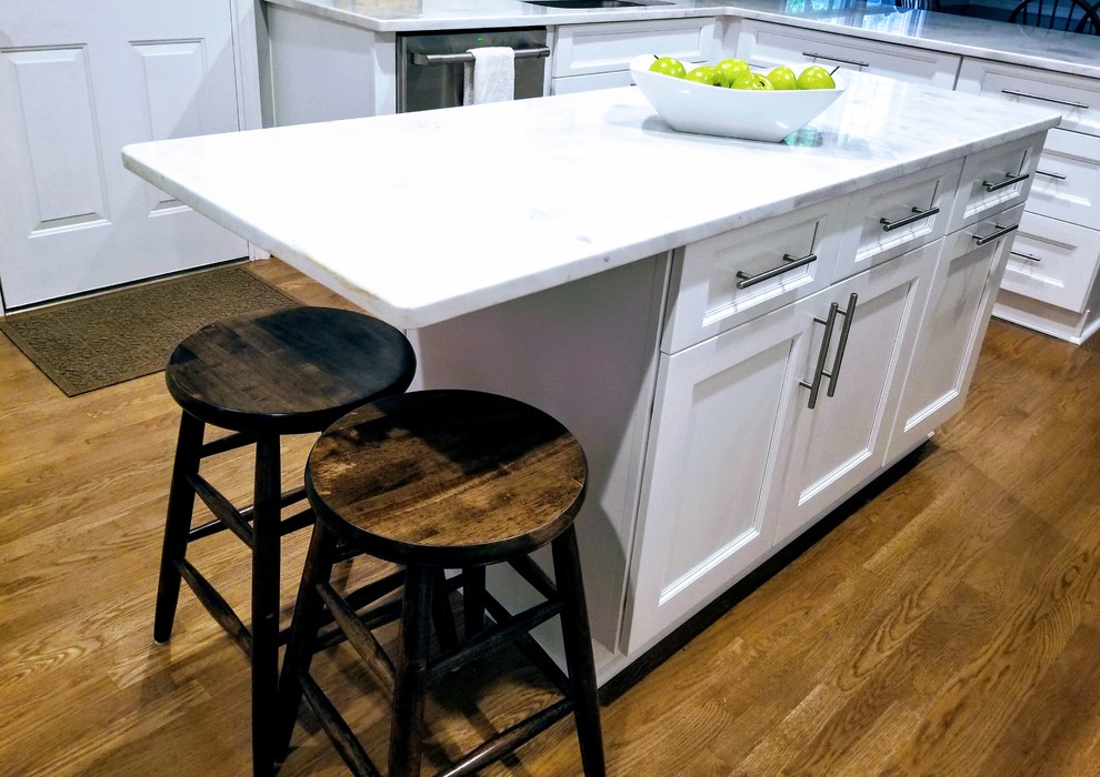 Inspiration for a large transitional u-shaped medium tone wood floor and brown floor enclosed kitchen remodel in Miami with an undermount sink, shaker cabinets, white cabinets, quartz countertops, white backsplash, subway tile backsplash, stainless steel appliances, an island and white countertops