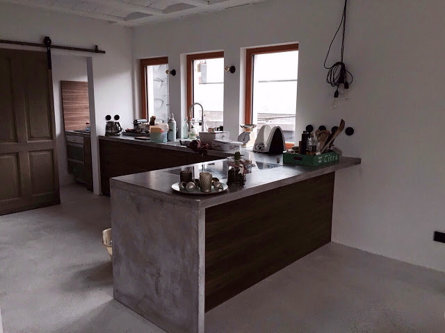 Contemporary l-shaped open plan kitchen in Frankfurt with flat-panel cabinets, white cabinets, black splashback and with island.