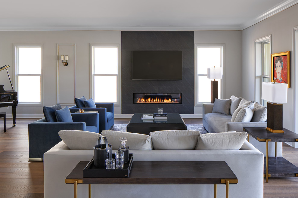 Inspiration for a mid-sized contemporary open concept living room in Los Angeles with black walls, medium hardwood floors, a ribbon fireplace, a stone fireplace surround, a wall-mounted tv and brown floor.