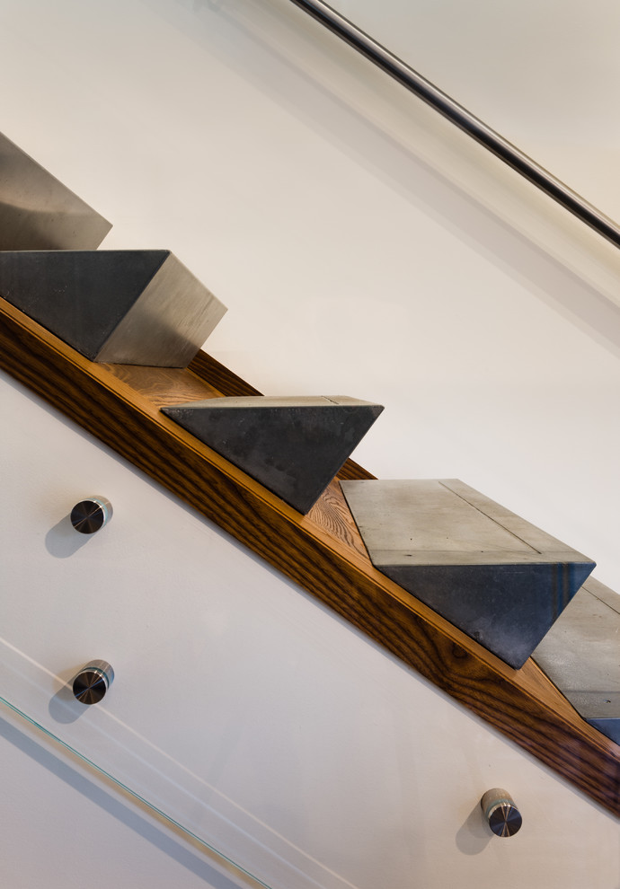 Photo of a mid-sized modern concrete l-shaped staircase in Baltimore with glass railing and wood risers.