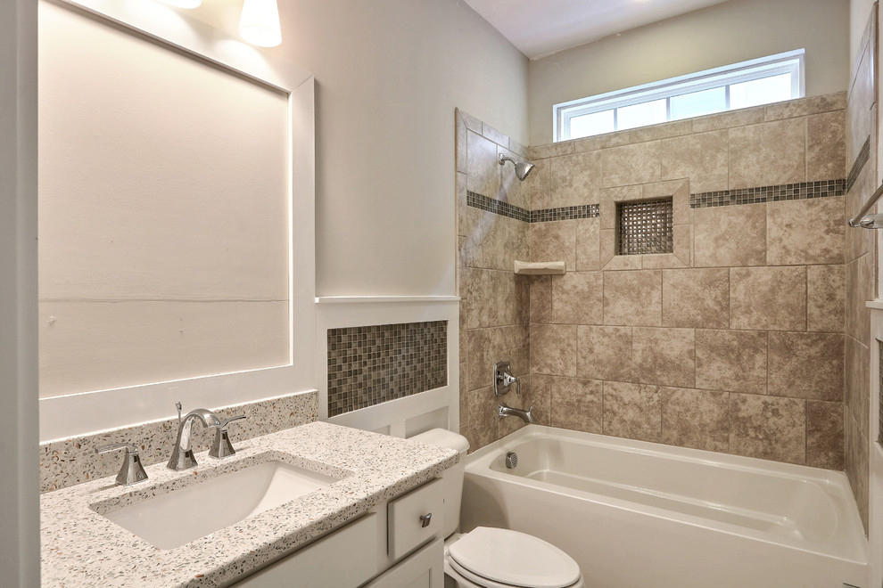 Design ideas for a mid-sized beach style master bathroom in Atlanta with a drop-in tub, a shower/bathtub combo, ceramic tile, grey walls, cement tiles, an undermount sink, granite benchtops, white cabinets, a two-piece toilet, flat-panel cabinets, beige floor and a shower curtain.