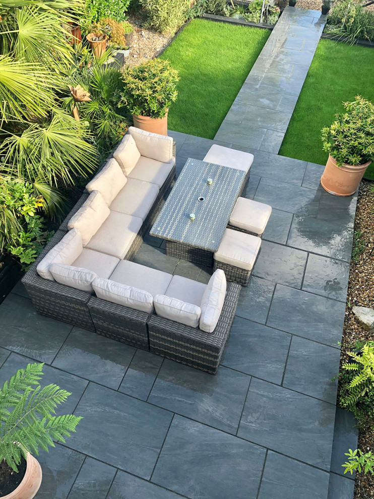 This is an example of a mid-sized contemporary backyard patio in Hertfordshire with tile.