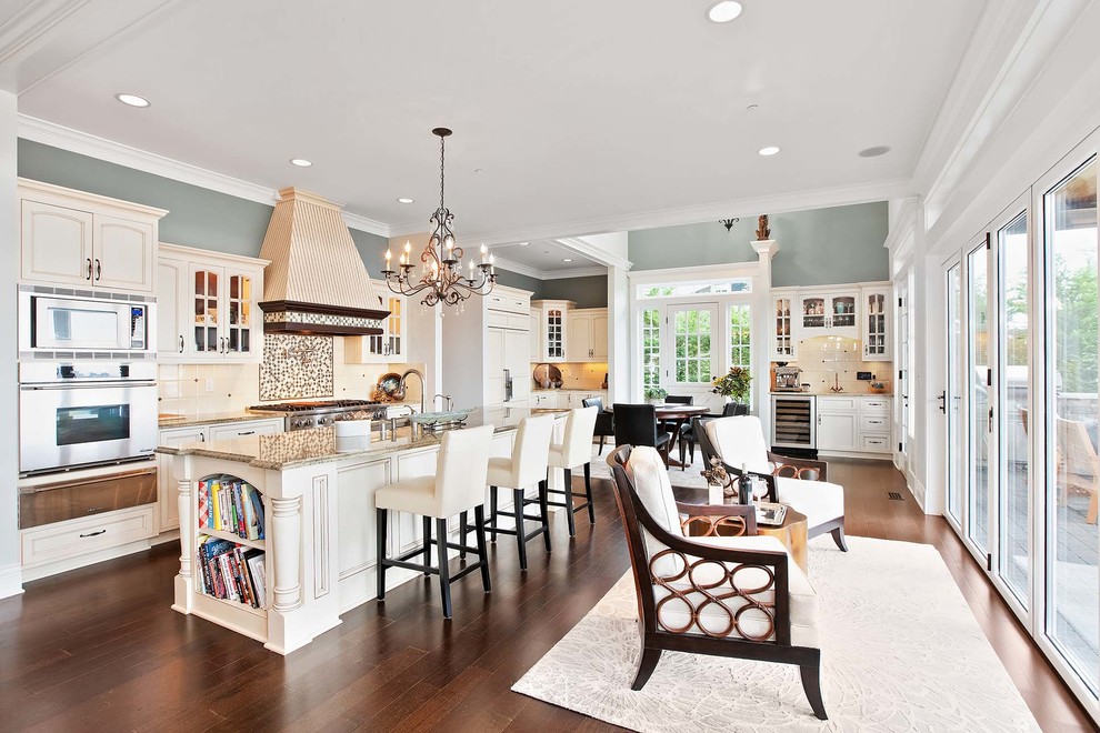 Inspiration for a traditional open plan kitchen in Seattle with glass-front cabinets, beige cabinets, multi-coloured splashback, stainless steel appliances, dark hardwood floors, with island, brown floor and beige benchtop.