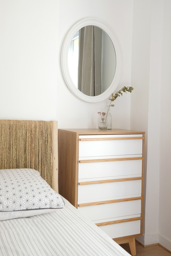 Ejemplo de dormitorio escandinavo pequeño con paredes blancas y suelo de madera clara