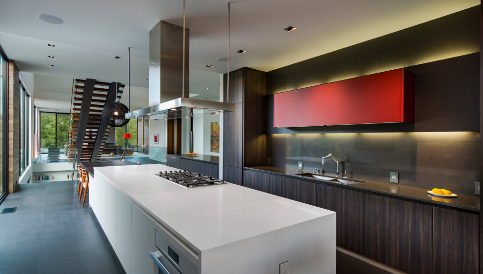 Eat-in kitchen - huge contemporary galley porcelain tile, gray floor and tray ceiling eat-in kitchen idea in DC Metro with flat-panel cabinets, dark wood cabinets, stainless steel appliances, an island and white countertops