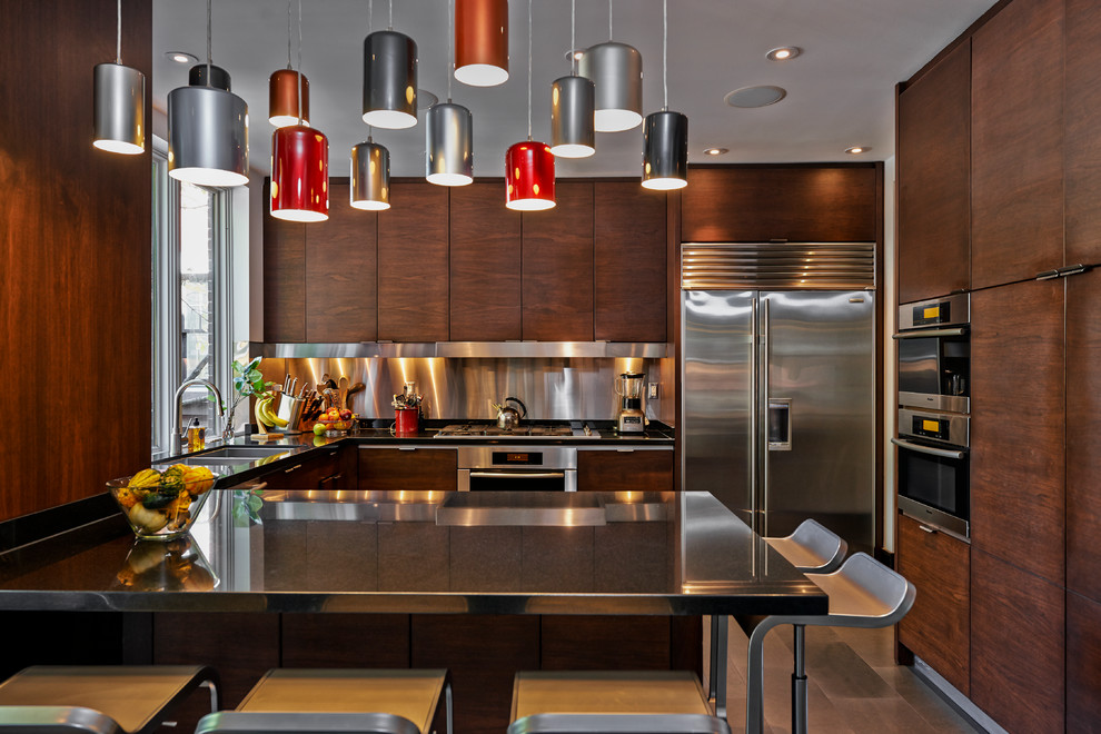 Inspiration for a mid-sized contemporary u-shaped separate kitchen in Toronto with a double-bowl sink, flat-panel cabinets, dark wood cabinets, stainless steel benchtops, metallic splashback, metal splashback, stainless steel appliances and slate floors.