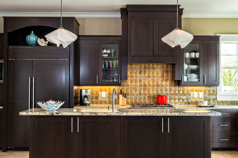 Inspiration for a transitional galley kitchen remodel in Miami with shaker cabinets, dark wood cabinets, yellow backsplash, paneled appliances and an island