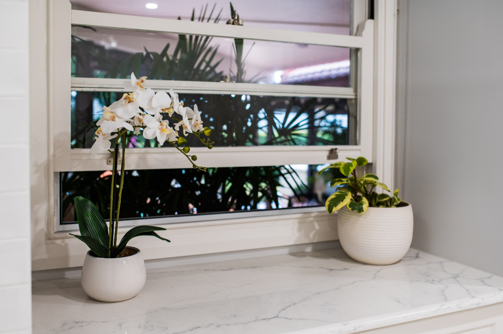 Inspiration for an expansive traditional galley laundry room in Sydney with an undermount sink, shaker cabinets, white cabinets, medium hardwood floors and beige benchtop.